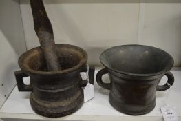 An early bronze mortar together with an early cast iron pestle and mortar.