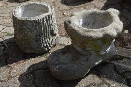 Reconstituted stone planter modelled as a boot together with another modelled as a tree trunk.