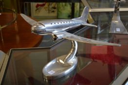 An aluminium model of an aeroplane on stand.