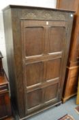 An oak single door hall cupboard.