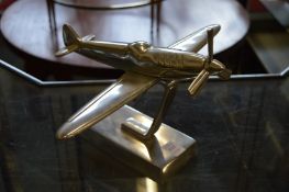 An aluminium model of an aeroplane on stand.