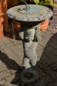 A reconstituted stone sundial in the form of a cherub.