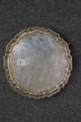 A silver salver with shaped border on three pad feet, 18oz.