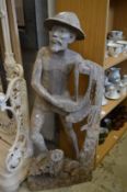 A large carved wood figure of a fisherman.