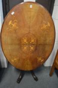 A Victorian inlaid walnut tilt-top oval breakfast table.