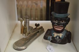 A cast iron money bank and an early stapler.