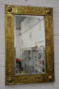 An Arts and Crafts brass framed mirror.