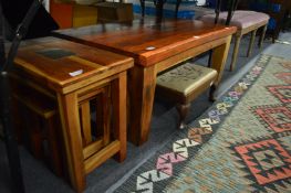 A hard wood coffee table with matching nest of tables together with a small stool.