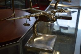 An aluminium model of an aeroplane on stand.