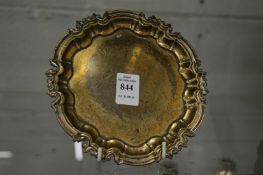 A silver waiter with shaped border on three scroll feet, 5oz.