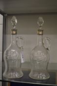 A pair of silver mounted cut glass decanters and stoppers.