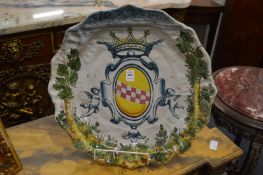 A large 18th century majolica charger decorated to the centre with an armorial.
