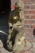 Reconstituted stone garden ornament modelled as a seated female nude.