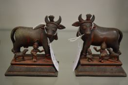 A small pair of Indian cast bronze models of bulls and other figures with traces of red painted