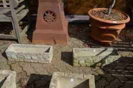 A pair of reconstituted stone trough shaped planters.
