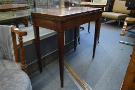 A mahogany rectangular fold-over card table.