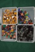 Four boxes of mixed colourful stones.