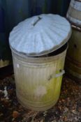 A galvanised dustbin together with watering cans etc.