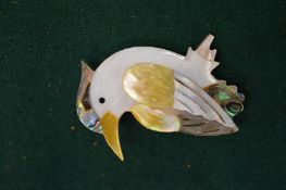 A mother of pearl toucan brooch.