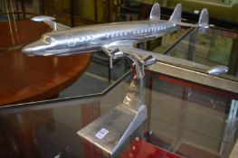 An aluminium model of an aeroplane on stand.