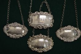 Four silver decanter labels.