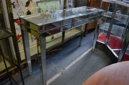 A stylish mirrored console table, damage to one leg.