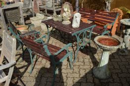 A cast metal and wooden slatted patio table with matching bench seat and pair of armchairs.
