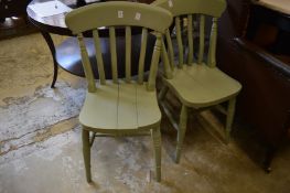 A set of four green painted kitchen chairs.