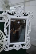 A painted decorative framed mirror.