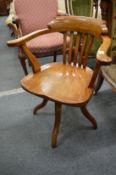 An Edwardian oak revolving office chair.