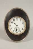 A GOOD SILVER MOUNTED OVAL TORTOISESHELL CLOCK by WILLIAM COMYNS. 11cms x 8cms. Birmingham 1918.