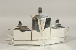 A CHRISTOPHER DRESSER DESIGN SILVER PLATED ART DECO TEA SET on a stand. 40cms long.