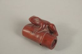 A CARVED WOOD FROG ON A BAMBOO NETSUKE, signed. 3.5cms.