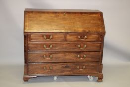 A GEORGE III MAHOGANY BUREAU the fall flap opening to reveal an arrangement of drawers and pigeon