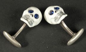 A PAIR OF STERLING SILVER AND ENAMEL SKULL CUFFLINKS.
