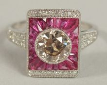 A PLATINUM RUBY AND DIAMOND PANEL-STYLE DRESS RING. Centre diamond 1.05ct. Calibre-cut rubies 0.