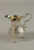 A SMALL GEORGE III SILVER CREAM JUG with repousse decoration. London 1766.