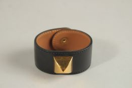 A HERMES LEATHER BRACELET with brass studs.