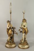 A GOOD PAIR OF CONTINENTAL GILDED FIGURES OF A YOUNG BOY AND GIRL, on circular bases, as lamps.