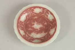 A CHINESE UNDERGLAZE RED KYLIN DISH. 20cms diameter.