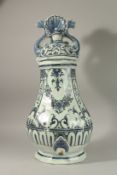 A LARGE BLUE AND WHITE FAIENCE CISTERN with cover and tap, decorated with garlands of flowers and