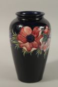 A GOOD MOORCROFT ANEMONE DESIGN VASE on a blue ground. Impressed, paper label and monogrammed. 27cms