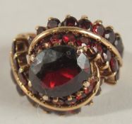 A GOLD GARNET RING. Ring Size M.