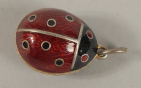 A SILVER EGG SHAPED LADYBIRD PENDANT.