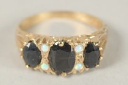 A 9CT GOLD THREE STONE SAPPHIRE AND OPAL RING. Ring size (O).
