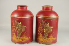 A PAIR OF TOLEWARE TEA JARS AND COVERS with Chinese scenes. 38cms high.