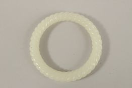 A WHITE TWIST JADE BANGLE. 8cms diameter.