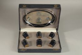 A RUSSIAN CASED VODKA SET comprising oval tray, 18cms long, and six vodka tots.
