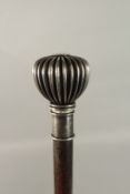 AN EDWARDIAN WALKING CASE with silver pommel top. 92cms long.
