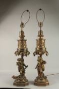 A VERY GOOD PAIR OF 19TH CENTURY GILDED METAL CUPID AND FRUITING VINE LAMPS on shaped bases. 66cms